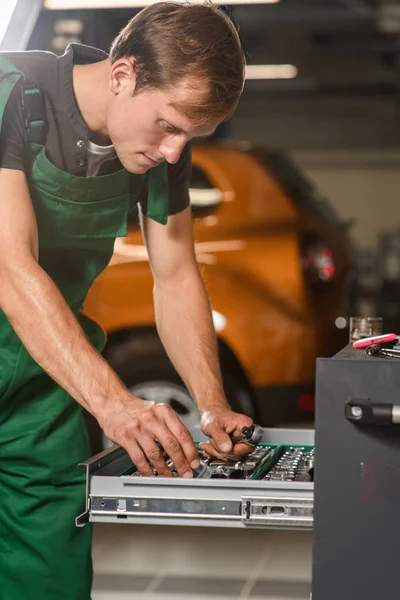 Joven Mecánico Elige Entre Las Herramientas Caja Para Reparación Automóviles —  Fotos de Stock