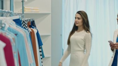 Genç mutlu kadın giyim mağazasında alışveriş