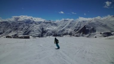 Genç bir snowboard bir tahta biniyor, çeşitli evler, güzel bir manzara görebilirsiniz, her şeyi karla kaplı
