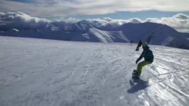 Bir snowboard dağ yamaçları, çok güzel bir dağ zirveleri, tüm karda, açık mavi ve güneşli gökyüzü manzarası fethetti