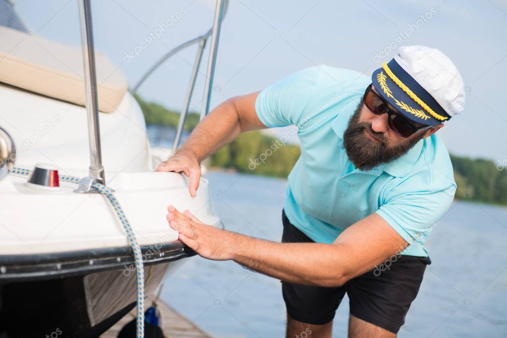A man with a beard checks his yacht