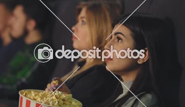 Patlamış mısır yemek ve bir sinema salonunda bir film izlemek güzel bir kız