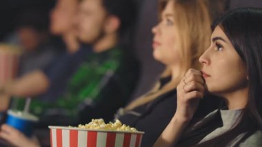 Esmer sinema film izliyor, patlamış mısır onun elinde tutan