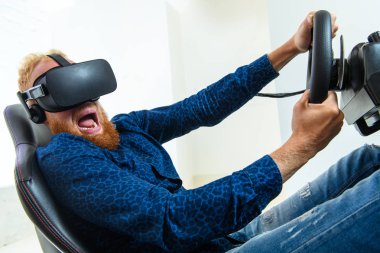 Bir genç, yakışıklı, bir mavi spor kıyafeti giyen, Yarış, bir sanal gerçeklik simülatörü çalış