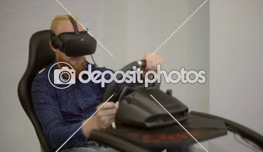 Genç bir adam özel bir sanal gerçeklik yüklemesinde yarış simülatörü çalış.