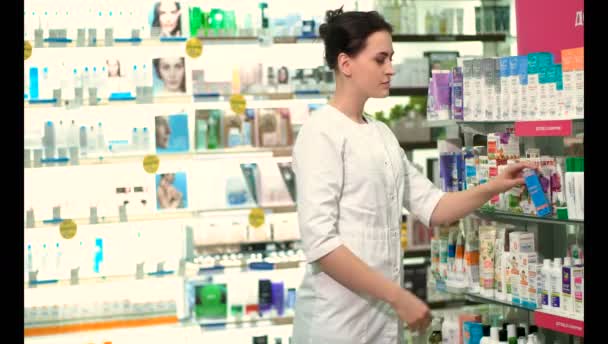 Chica Farmacéutica Una Farmacia Muestra Mano Para Llamarla — Vídeo de stock