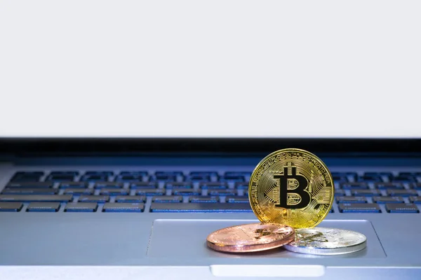 Bitcoin monedas en ordenador portátil pista pad — Foto de Stock