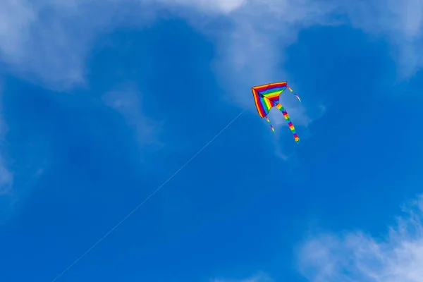 Изображение цветного воздушного змея, летящего в небе — стоковое фото