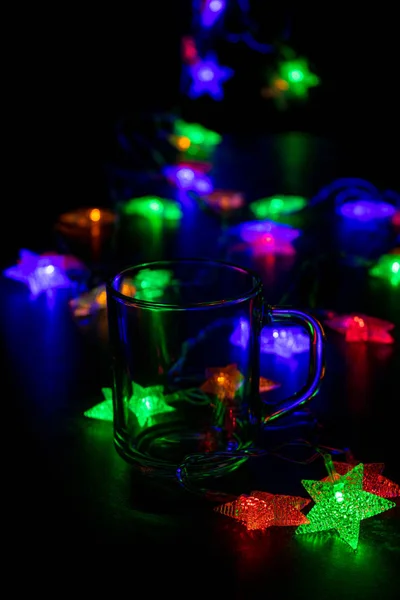 Glass teacup and  garland in the dark