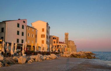 Sokak kafe ve Sunrise hafif yaz sabahı Piran, Slovenya, deniz feneri ile Adriyatik Denizi şeridinin ısmarlayarak. Seyahat hedef sahne