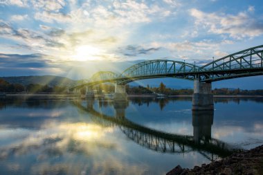 Amazing view of Maria Valeria bridge with reflection in Danube river on Slovak-Hungary border at sunrise. Esztergom, Hungary. Autumn morning. Travel destination clipart