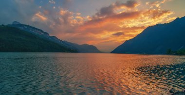 Güzel gün batımı Dört Kanton Gölü (Vierwaldstattersee) üzerinde gökyüzü yanma ile su, Kanton Schwyz, İsviçre'yansıtıyordu. 