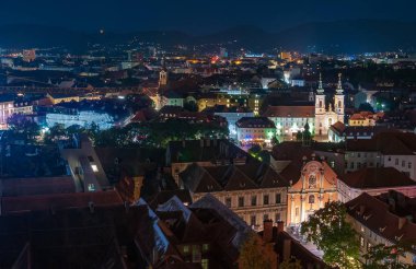 Graz, Avusturya şehir gece panoramik görüntüsü. Aydınlatılmış cephe Trinity Kilisesi ve Mariahilfkirche. Graz tarihi merkezi Unesco Dünya Mirası listesine inscripted