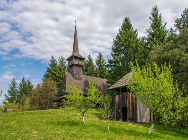 Manzara arka planda Maramures - Romanya'nın tarihi bölge üzerinde geleneksel maramures neo-gotik ahşap kilise ile kırsal manzara bahar