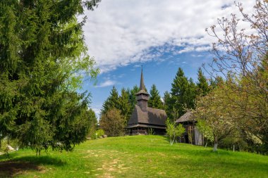 Manzara arka planda Maramures - Romanya'nın tarihi bölge üzerinde geleneksel maramures neo-gotik ahşap kilise ile kırsal manzara bahar