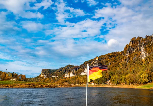 Pintoresco paisaje atumn con la bandera nacional ondeando de Alemania. Río Elba, Sajonia, Alemania — Foto de Stock