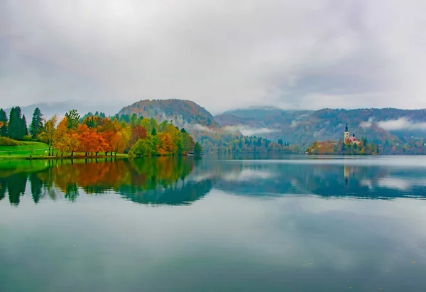 Autumn scenery of colorful trees reflected in lake water, Bled Lake, Slovenia — Stock Photo, Image