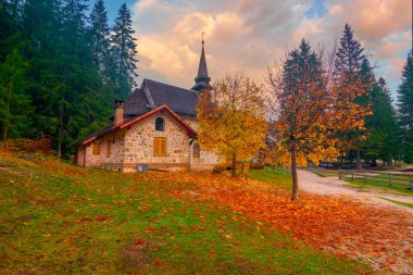 Lago di Braies Gölü, Dolomite Alpleri, Güney Tyrol, İtalya 'da küçük bir şapelin muhteşem sonbahar manzarası.