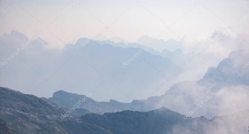 Beautiful background with blue ridge in hazy mountains. Julian Alps, Slovenia