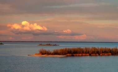 Güzel bulutlar, sonbahar akşamı Ukrayna 'nın Cherkasy yakınlarındaki Dinyeper nehrinin üzerinde aydınlanıyor.