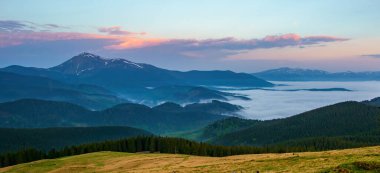 Ukrayna, Karpat Dağları 'ndaki dağlık çayırda muhteşem bir sonbahar akşamı. Petros zirvesi ve Svydovets dağ sırası. Alçak bulutlarla kaplı vadi.
