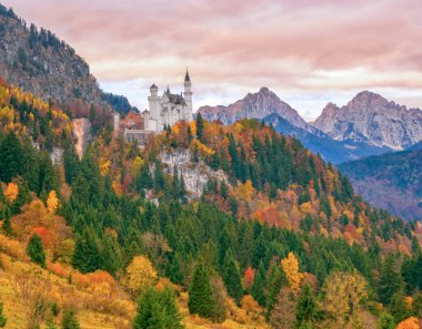 Neuschwanstein şatosunun sonbahar sabahı dağ arka planındaki manzarası