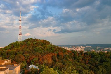 Gökyüzü, Lviv, Ukrayna karşısında, sararmış sonbahar ağaçları ve televizyon kulesiyle High Castle Hill 'in muhteşem panoramik manzarası. UNESCO dünya mirası sahası