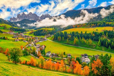 Güneşli bir günde arka planda dağ zirveleri olan Santa Maddalena köyünde renkli bir sonbahar manzarası. Dolomite Alpleri, Güney Tyrol, İtalya.