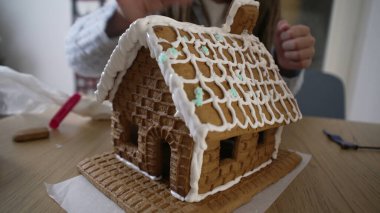 Küçük kız zencefilli kurabiye dekorasyonunun son detaylarını ekliyor.