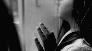 Mutsuz, kasvetli, zor zamanlarda depresyona giren küçük bir kız. Yüzü ve eli cam pencereye yaslanmış, siyah-beyaz, tek renkli, yapayalnız hisseden bir çocuk.