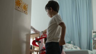 Küçük çocuk otopark oyuncağıyla yatak odasının zemininde oynuyor. Çocukluk eğlence aktivitesi