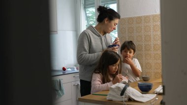 Aile Mutfağı Sahnesi. Anne ve çocuklarının aile hayatı anı. Anne, oğul ve kızıyla atıştırıyor.