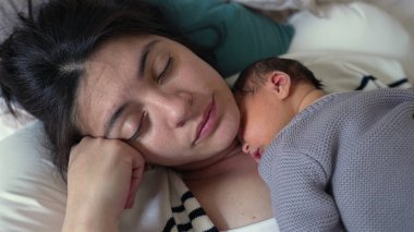 Anne ve yeni doğan bebek huzur içinde uyuyorlar, bebek göğsünde dinleniyor, huzurlu bir yuvada huzurlu ve şefkatli bir bağ ve sevgi anı yakalıyorlar.