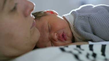 Yeni doğan bebek anne göğsünde dinleniyor. Huzur içinde uyuyor. Ebeveyn ve çocuk arasındaki derin bağı ve sevgiyi simgeliyor..