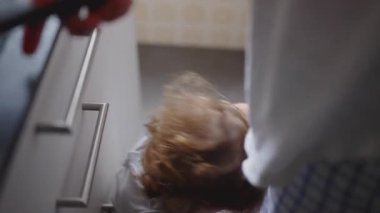 Ufaklık dikkat çekmek için ağlıyor ve annesini mutfak tezgahından itiyor. Sonunda onu kollarına almadan önce, evde samimi, duygusal bir aile anı yaşıyor.