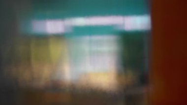 Mavi ve sarı tonlu iç mekanın soyut bulanık görüntüsü, rüya gibi katmanlı yansımaları, dokulu cam efekti, minimal sanatsal kompozisyon ve yumuşak ruh hali.