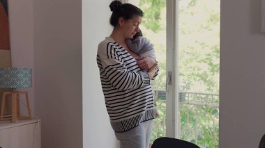 Anne ve küçük oğlu pencerenin kenarında yan yana duruyor, sessiz bir bağlantı ve yansıma anını paylaşıyorlar. Aile bağlarının şefkati ve birlikte olmanın rahatlığı..