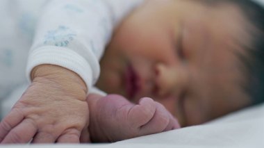 Yeni doğan bebek, el pençe divan uyuyor. SD 480p 'lik rahat bir ortamda bebekliğin hassas ve nazik doğasını vurguluyor.