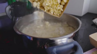 Kaynar suya taze makarna atmak, ev yapımı tortellini pişirmek, geleneksel İtalyan mutfağı hazırlığı, mutfak pişirme süreci.