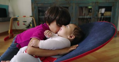 Büyük kardeş, bir fedainin üzerindeki küçük kardeşle şefkatle iletişim kuruyor. Bir yuva ortamında aralarındaki güçlü bağı ve sevgiyi vurgulayan dokunaklı ve sevgi dolu bir an yaratıyor..