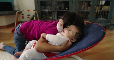 Büyük kardeş, bir fedainin üzerindeki küçük kardeşle şefkatle iletişim kuruyor. Bir yuva ortamında aralarındaki güçlü bağı ve sevgiyi vurgulayan dokunaklı ve sevgi dolu bir an yaratıyor..