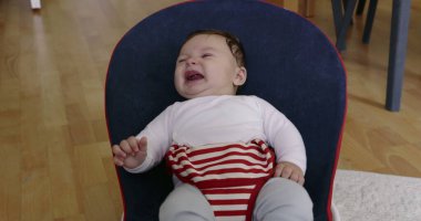 Bebek bir fedaide uzanıyor, mutlu ve rahat görünüyor, rahat bir ev ortamında huzur ve huzur dolu bir an sergiliyor, çocukluk yıllarının masumiyetini ve neşesini vurguluyor.