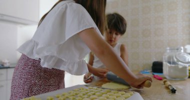 Kız ve erkek mutfaktan para kazanıyor, kız oklava kullanıyor, oğlan asistanı, aile yemekleri, takım çalışması, parlak ev dekorasyonu, öğrenme ve bağ kurma ile uğraşan çocuklar