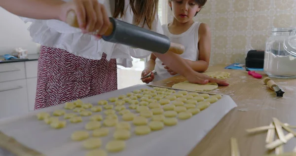 Kız ve erkek mutfaktan para kazanıyor, kız oklava kullanıyor, oğlan asistanı, aile yemekleri, takım çalışması, parlak ev dekorasyonu, öğrenme ve bağ kurma ile uğraşan çocuklar