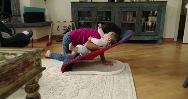 Büyük kardeş, bir fedainin üzerindeki küçük kardeşle şefkatle iletişim kuruyor. Bir yuva ortamında aralarındaki güçlü bağı ve sevgiyi vurgulayan dokunaklı ve sevgi dolu bir an yaratıyor.