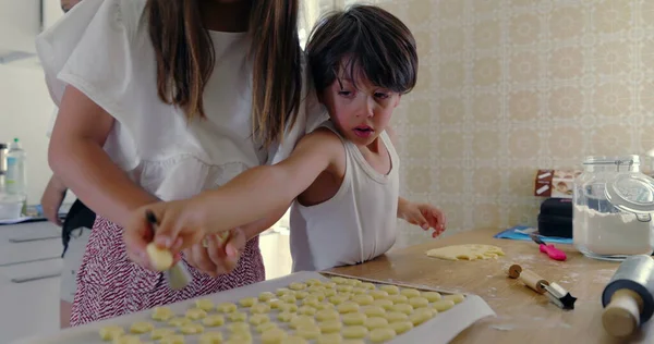 Mutfakta para kazanan kardeşlerin yakın çekimi, kız ve oğlan aşçılık işine odaklandı, aile yemekleri aktivitesi, anne arka planda, takım çalışması, bağ kurma, parlak mutfak