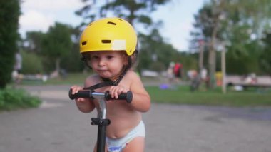 Yürüyen çocuk sarı başlık takarken denge ve direksiyon becerilerini geliştiriyor, odaklanmayı, kararlılığı ve erken motor gelişimini gösteriyor.