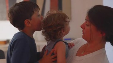 Anne kucağında bebek, ağabeyi ise evde iki kardeş arasında bağ, sevgi ve yakınlık gösteren yakın, samimi ve şefkatli bir aile anı yaşıyor.