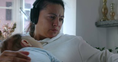 Anne, bebeğin göğsünde uyuması, kulaklık takması, dizüstü bilgisayar kullanması, samimi, otantik yaşam tarzı, rahat bir ev, dengeli bir iş ve ebeveynlik.