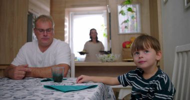 Aile masada bir yemeği paylaşır, anne bulaşıkları servis ederken baba ve oğul doğal sohbetler yapar, bağlantıyı ve sıcaklığı ön plana çıkarır.